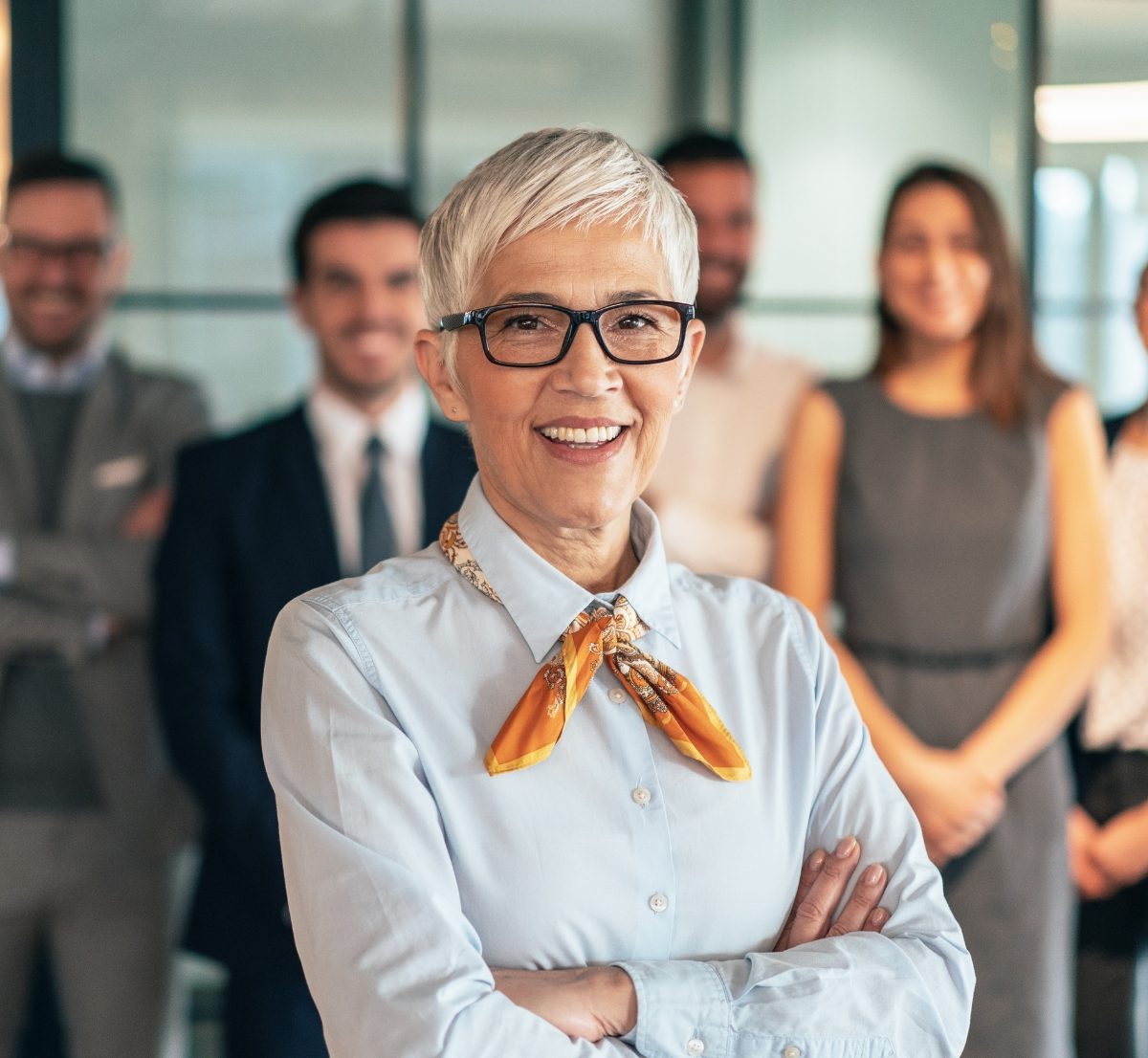 Photo d'une femme senior avec des collègues de travail en arrière plan
