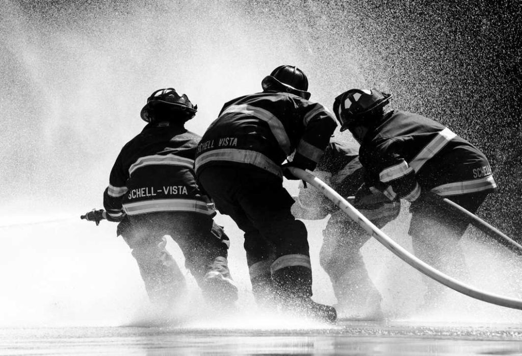 photo noir et blanc de pompiers en action