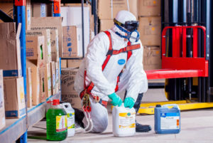 man in a suit handling hazardous materials