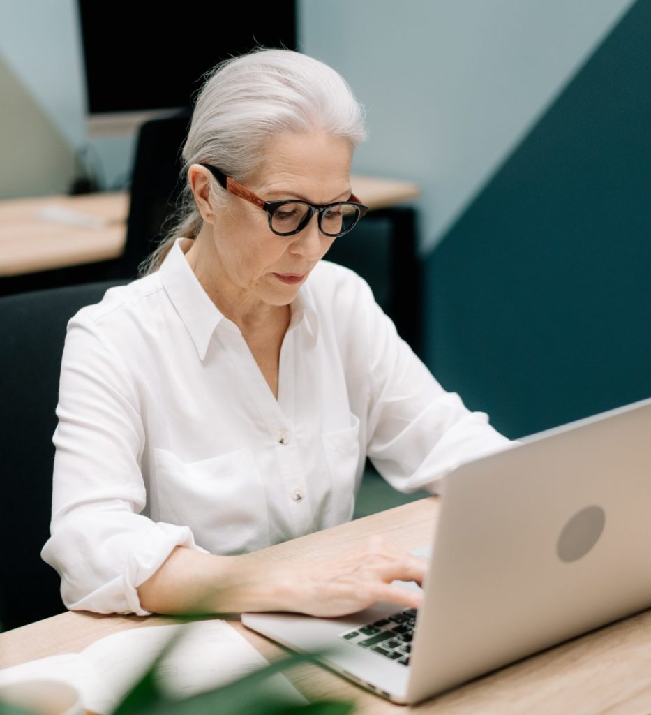 Femme senior dans un bureau en entreprise devant son ordinateur