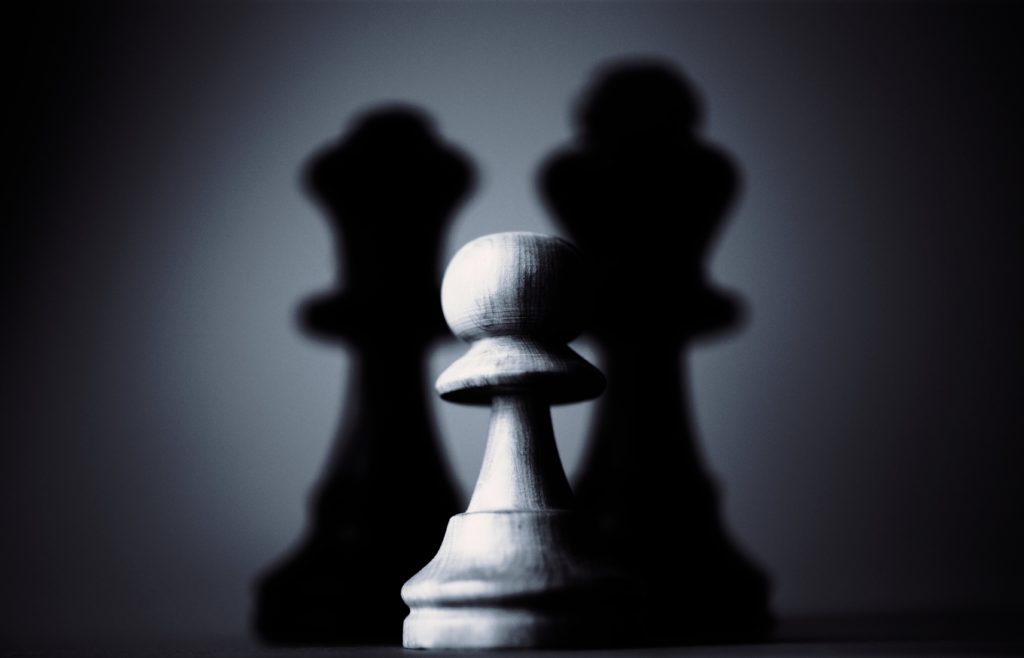 pièces du jeu d'échecs Un pion blanc devant deux pièces noirs