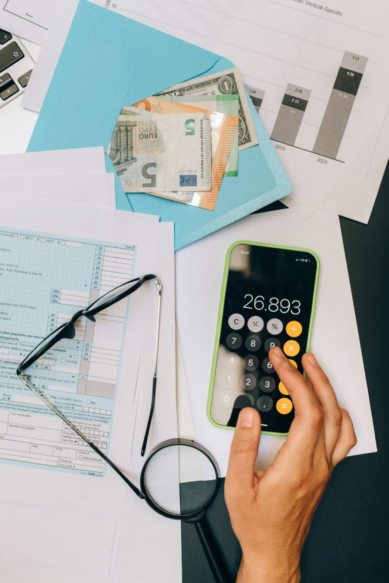 Image d'une femme avec une facture et une calculatrice dans son téléphone