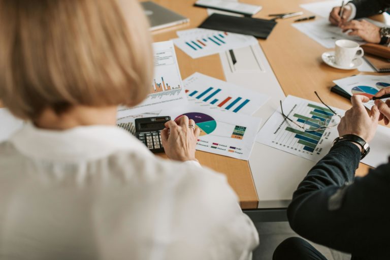 Femme devant un bureau avec des analyses financières sur papier